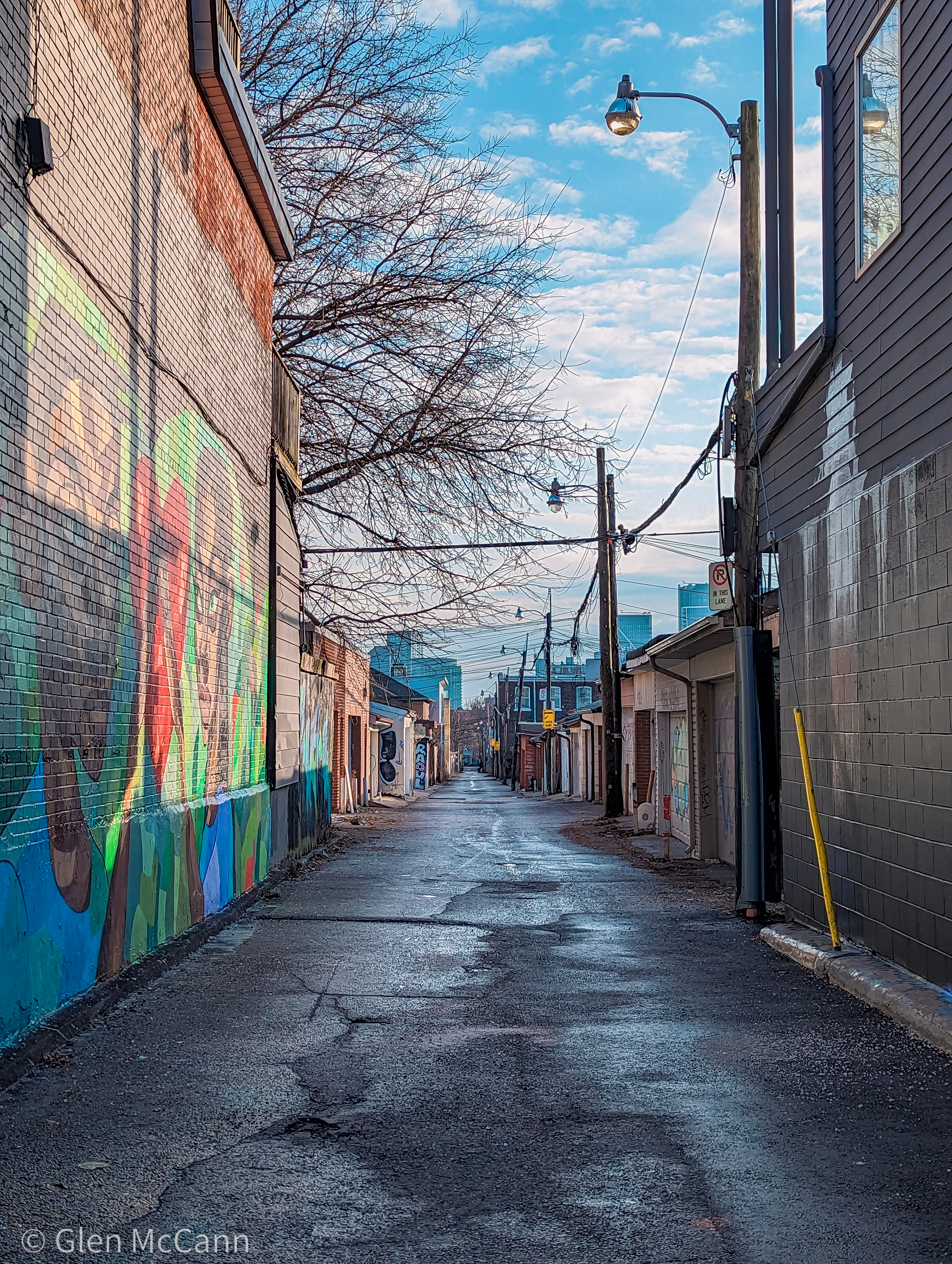 Photo of an empty alley, looking down the row of buildings.