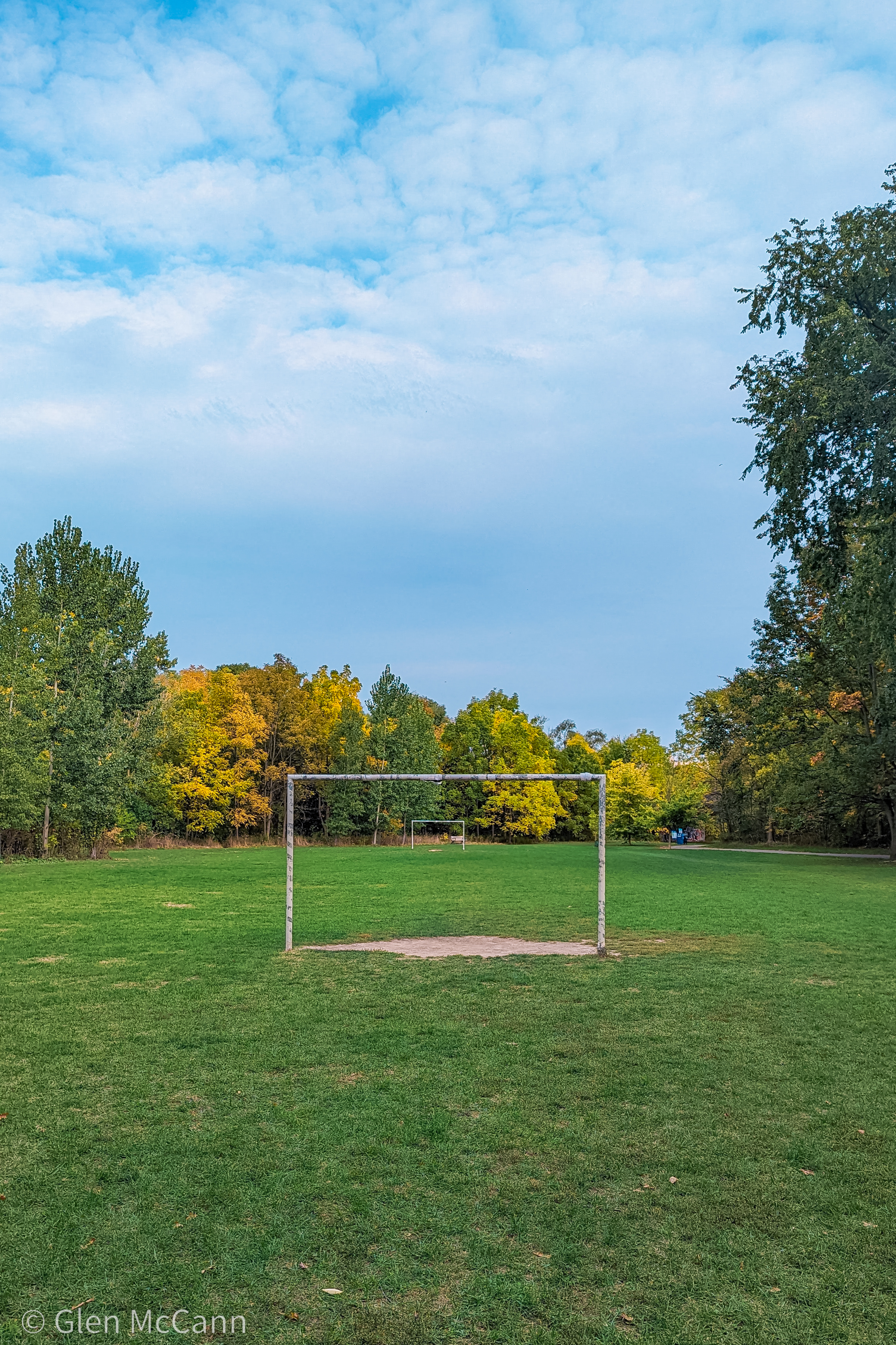 An empty soccer field in the summer, viewed from behind one of the goals.